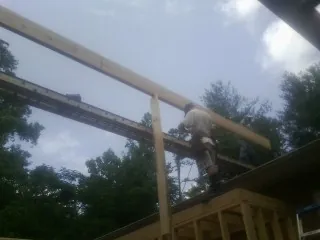 Carpenter setting a ridge beam over a new addition frame — Ice Dam Removal by Roofing Brothers in South Woodstock