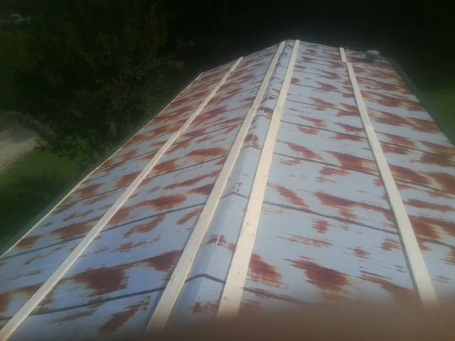 Rusted metal roof panels with new wood purlins before replacement — Storm Damage Roof Repair in South Woodstock by Roofing Brothers