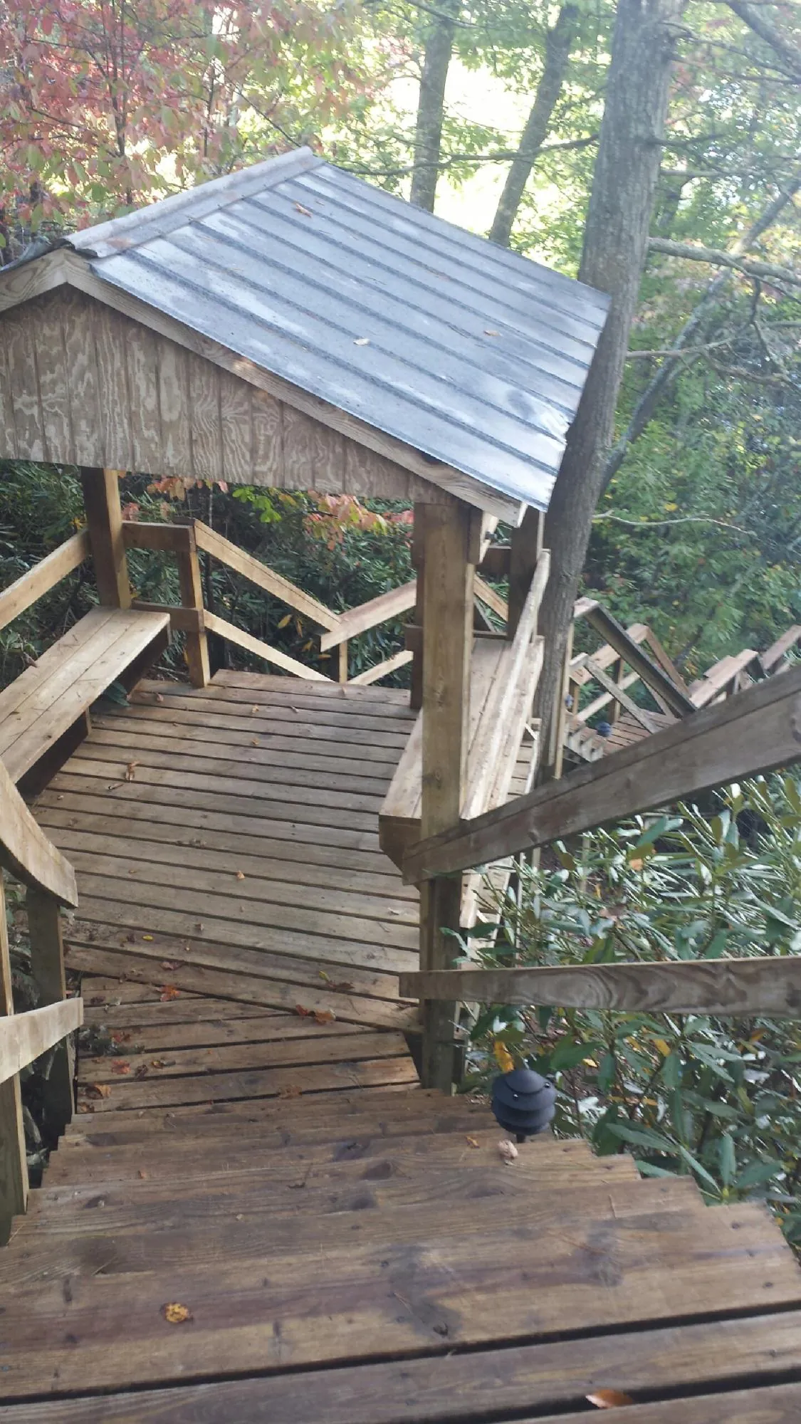 Metal roofed shelter over wooden steps on a wooded walkway — Skylight Repair & Installation work by our crew in South Woodstock