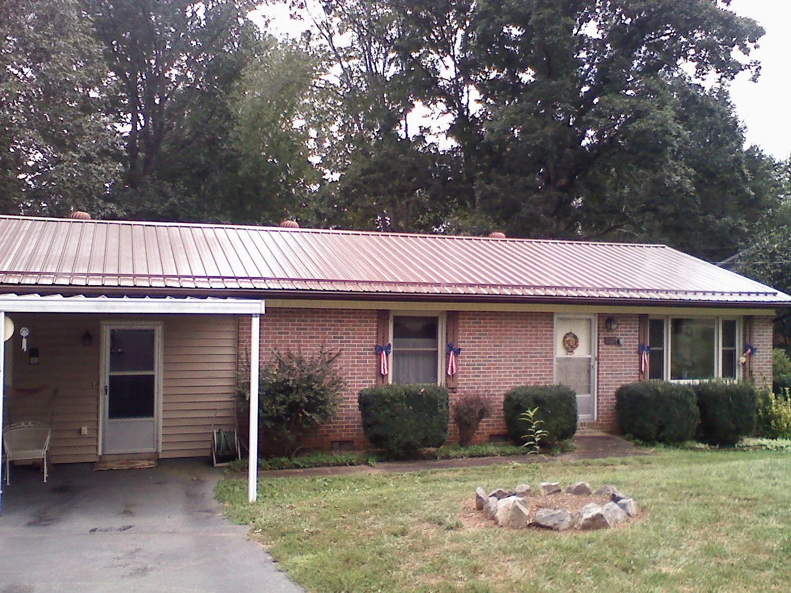 Bronze metal roof and carport on a brick ranch home — Roof Repair work by our crew in South Woodstock